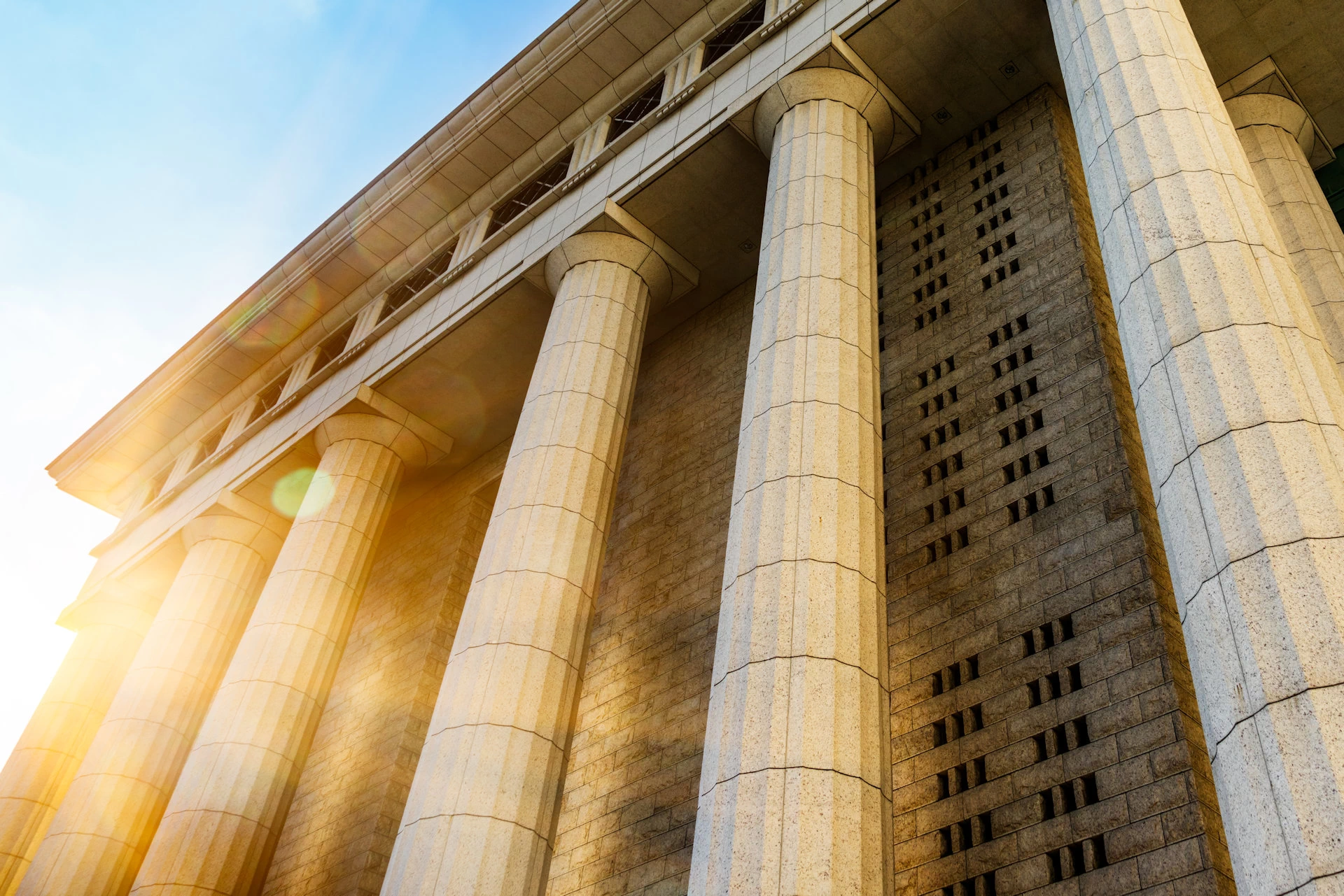 Top portion of a courthouse with Corinthian columns. With the title Contact Us written on top.